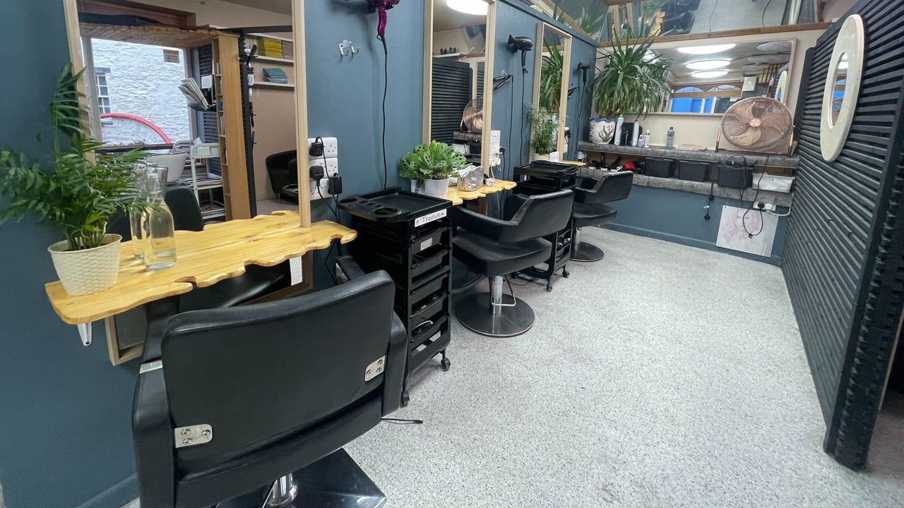 Styling stations with blue-grey walls, pine counters and plants